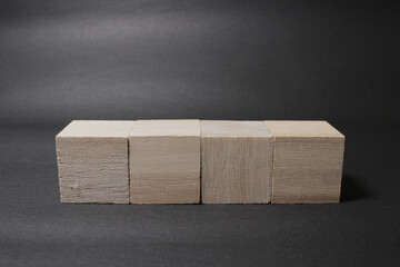 a wooden cube isolated on a dark background - obrazy, fototapety, plakaty