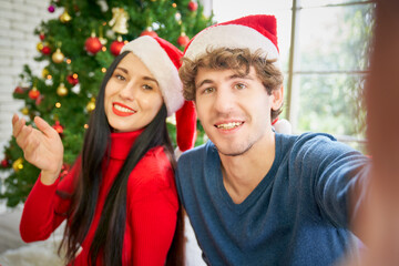 Couple male and female happy for video call to friends on camera phone in christmas party