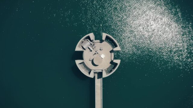 Dam on lake. Round reservoir blue water top down. Special equipment for production electricity. Hydropower generation. Ecological problem. Ripples, water texture. Nature environment. Drone zoom out
