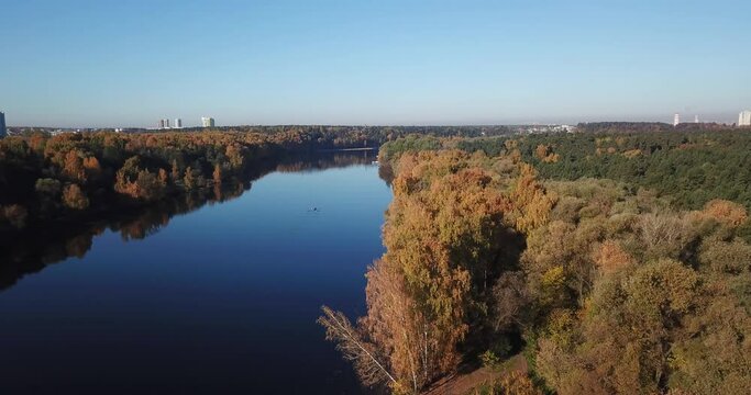 4K bright sunny autumn morning aerial drone video of Moskva River and yellow red forest park in Moscow, Russia