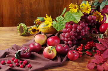 Apples, grapes and drapery on a wooden table. 