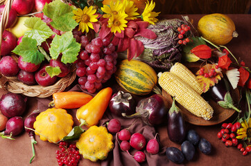 Harvest on Thanksgiving Day. Vegetables, fruits and flowers in a basket on a wooden table.