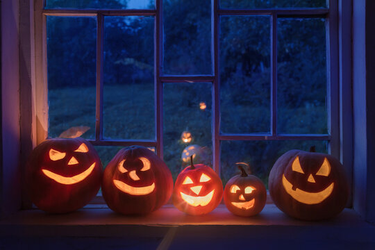 Halloween pumpins on windowsill with ghost outside  window