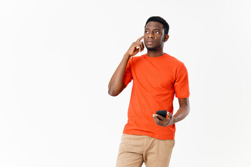 Fototapeta premium cute African American in a t-shirt and shorts with a mobile phone 
