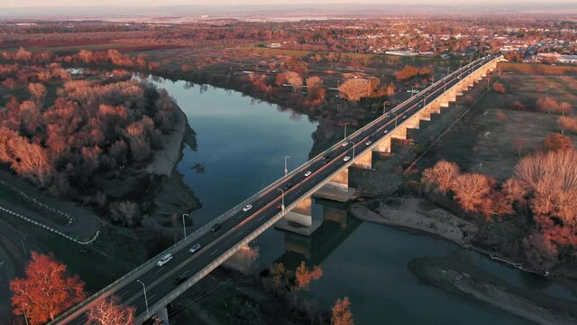 Aerial: Yuba City and bridge over Feather River at sunset, California, USA