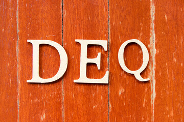 Alphabet letter in word DEQ (Abbreviation of Delivered Ex Quay) on old red color wood plate...