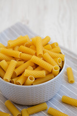 Dry Rigatoni Pasta in a gray Bowl, side view.