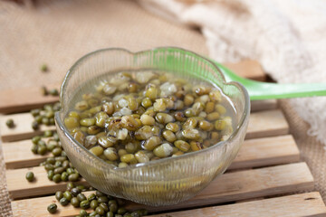 Green beans boiled sugar in a glass cup on a gray background