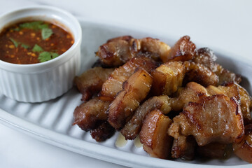 Deep fried pork belly with fish sauce and spicy sauce in white plate
