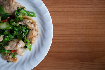 Stir-fried pork with kale and chilli in a white plate