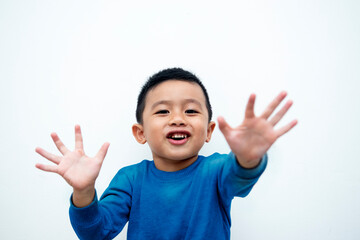 Cute Asian boy in blue shirt waving hands smiling