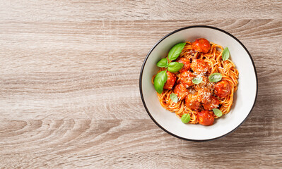 Spaghetti pasta portion with meatballs and tomato sauce. Wooden background. Top view 