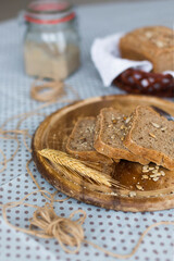 Slices of homemade rye bread with seeds, sesame seed, flaxseed on round wooden plate