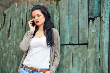 Obraz premium Young cute female using smartphone on the street.