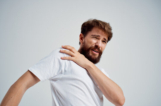 emotional man in a white t-shirt stress medicine pain in the neck isolated background