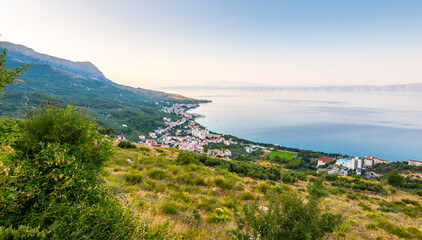 Aerial view of Tucepi town, Croatia. Makarska - Dalmatia region. View of city, sea and isle ind the background. Sunrise time.