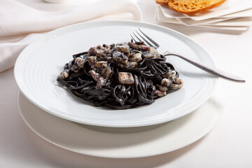 De cerca calamares en su tinta con pasta. close up of squid in its ink with pasta
