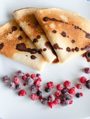 Homemade pancakes with berries. Lie on a white plate.