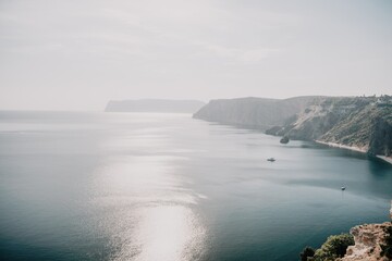 Aerial view from above on calm azure sea and volcanic rocky shores. Small waves on water surface in motion blur. Nature summer ocean sea beach background. Nobody. Holiday, vacation and travel concept