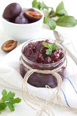 Plums jam. Sauce of plums with spice in a preserving glass.