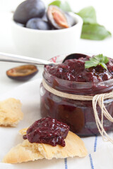 Plums jam. Sauce of plums with spice in a preserving glass.
