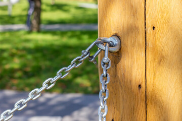 Steel chain connection. Wooden post with fastening.