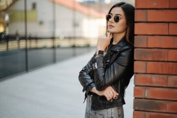 Portrait of young trendy girl walking along the street