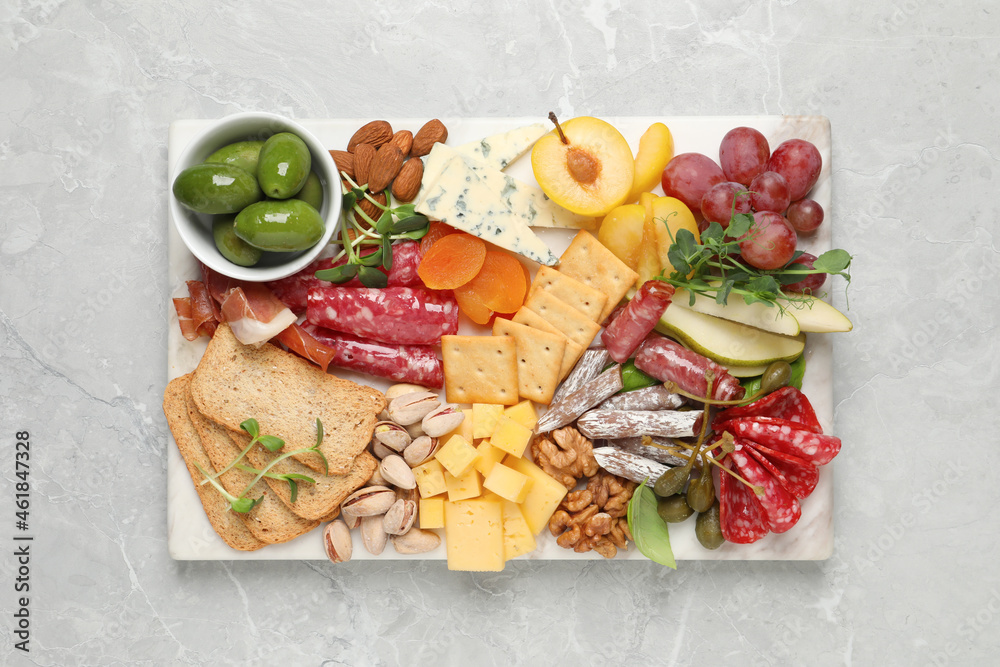 Wall mural different tasty appetizers on light marble table, top view