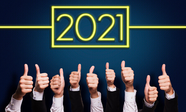 many hands with thumbs up to 2021 formed by a neon sign