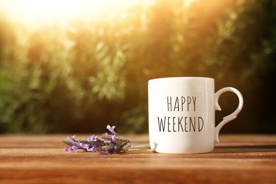 coffee cup with the text happy weekend on wooden table outdoors
