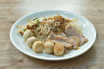 boiled dry vermicelli thin rice noodles topping slice pork and meatball dressing sweet black soybean sauce on plate