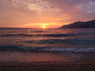 Sunset over the sea, red-orange sky and sea on a summer evening, Croatian coast, Dalmatia