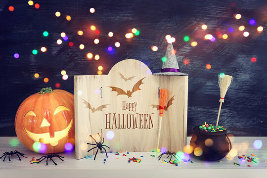 holidays image of Halloween. spiders, pumpkin and wooden board frame with text