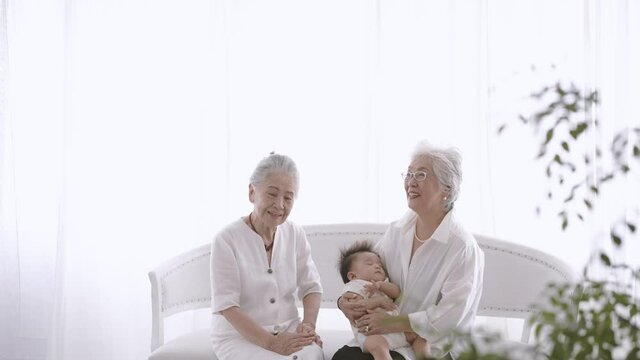 赤ちゃんを抱っこするシニア女性たち