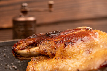 Pieces of roast duck with spices in a frying pan, close-up, selective focus.