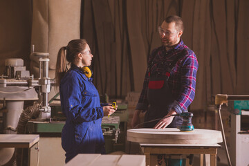 Female carpenter focused on measuring wood plank