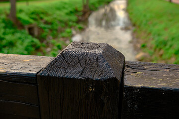 Fototapeta premium Cross type wooden columns and bridge parts in small shed in Bursa botanical park and water river background in forest background.