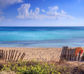 Summertime: fence on the beach in Puglia, Italy: the sandy beach of San Pietro in Bevagna, a...