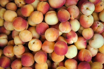Detail of a box of sweet orange peaches in an organic greengrocer