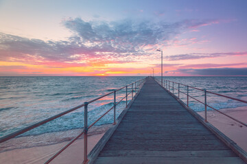 Fototapeta na wymiar Port Noarlunga jetty with people during pink sunset, South Australia