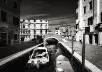 View of the Cannaregio Canal in Venice. Boats and bridges. Veneto. Venice. Italy. Black and white.