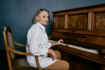 elderly woman sitting on a chair near the piano music performance