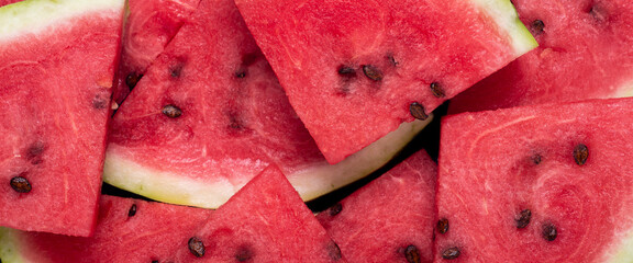 Background of slices of juicy red watermelon. Top view, flat lay. Banner