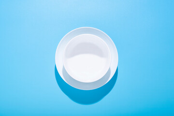 Clean white plates, dishes on a blue background. Top view, flat lay