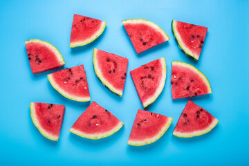 Slices of juicy watermelon on a blue background. Top view, flat lay