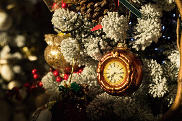 Close up of holidays location with gold clock toys, garlands on Christmas tree