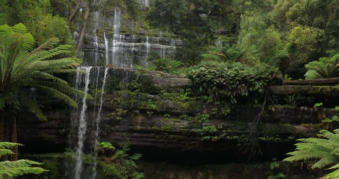 Top to Bottom tilt pan with sound of the famous Russell Falls, with a tiered cascade amid rocks and ferns at Mount Field National Park, a very visited tourist destination in Tasmania, Australia