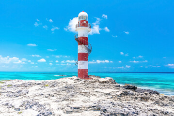 Lighthouse on rocky coastal shore of beautiful seascape against cloudy sky. Lighthouse on seashore