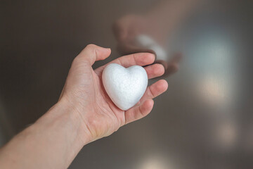 White heart in female hand.Organ donation and insurance concept.
World heart health concept. World organ donation day. Healthy heart concept for healthy life. Selective focus.