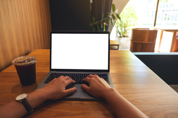 Mockup image of a woman using and typing on laptop with blank white desktop screen